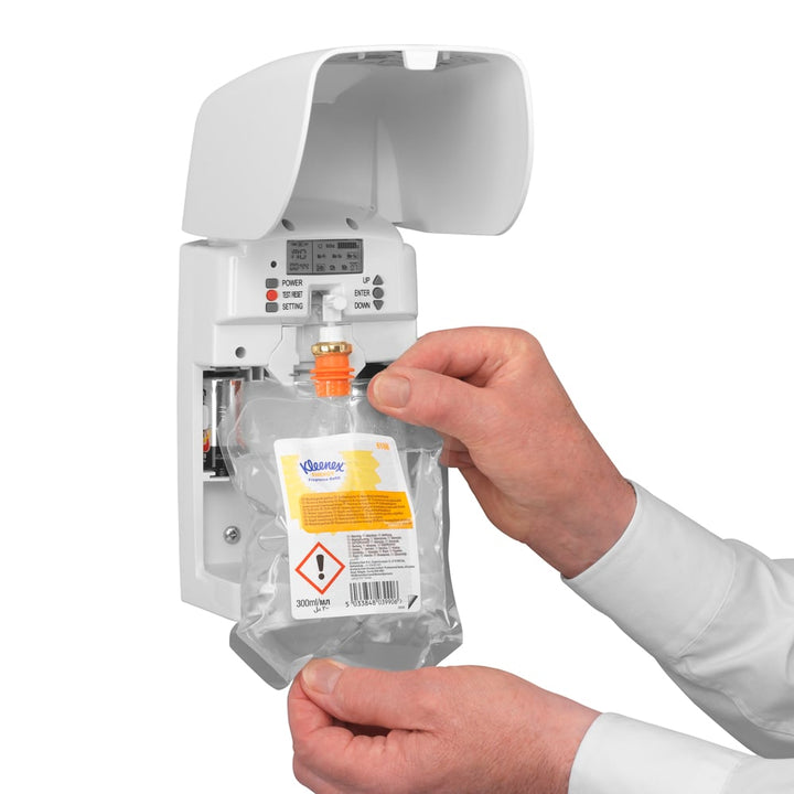 A Person Putting a New Kleenex Air Care Refill Into an Open White 6188 Kleenex Air Care Dispenser