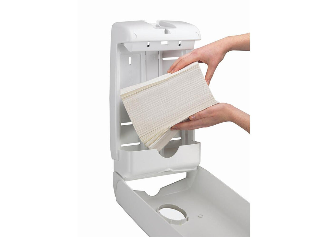 A Person Putting a Stack of Slimfold Wipes into a White U7024 Aquarius Slimfold Hand Towel Dispenser